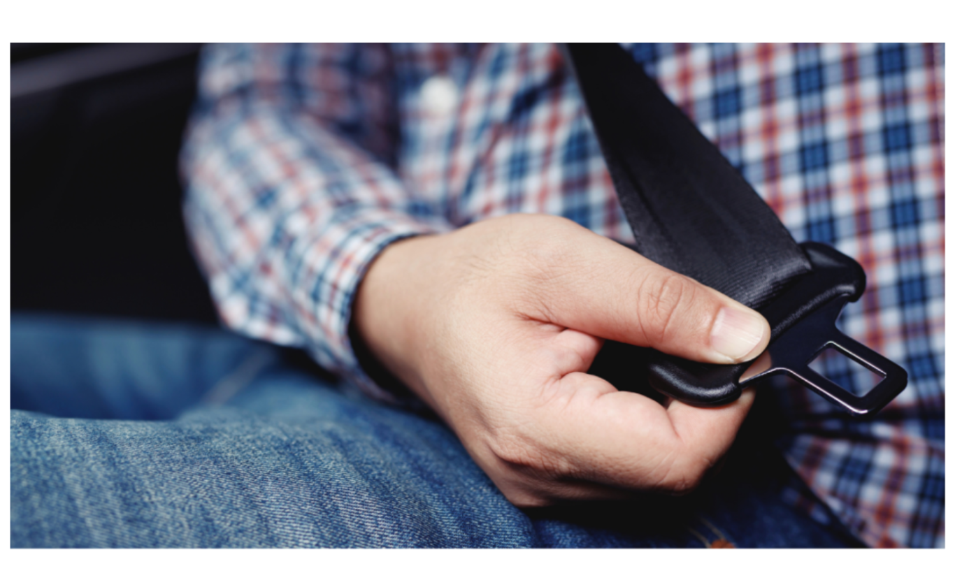 A person fastening a seatbelt while sitting in a car.